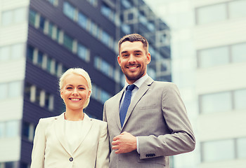 Image showing smiling businessmen standing over office building