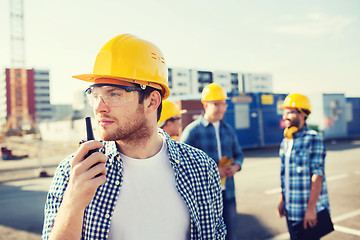 Image showing group of builders in hardhats with radio