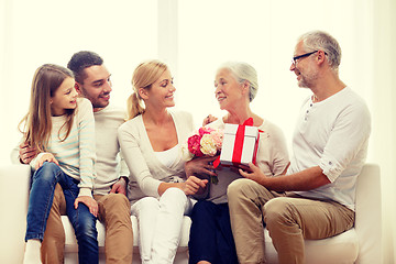 Image showing happy family with bunch and gift box at home