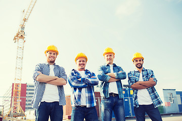 Image showing group of smiling builders in hardhats outdoors