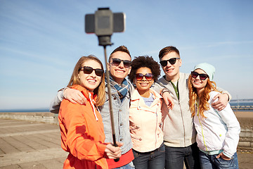 Image showing smiling friends taking selfie with smartphone