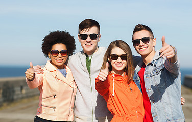 Image showing happy teenage friends in shades hugging outdoors