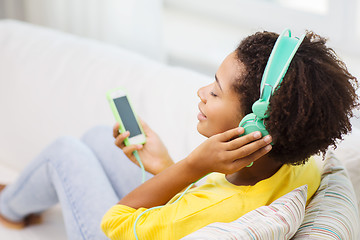 Image showing happy african woman with smartphone and headphones