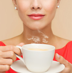 Image showing smiling woman in red dress with cup of coffee