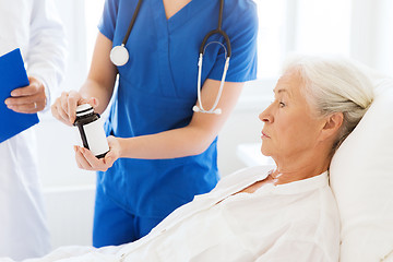 Image showing doctor giving medicine to senior woman at hospital