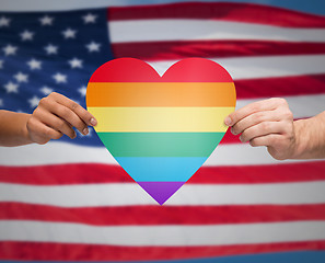 Image showing hands with rainbow heart shape over american flag