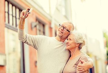 Image showing senior couple photographing on city street