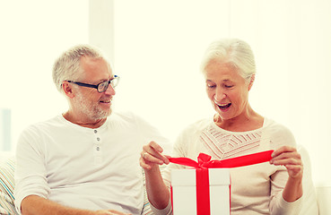 Image showing happy senior couple with gift box at home