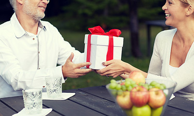 Image showing happy family giving present in summer garden