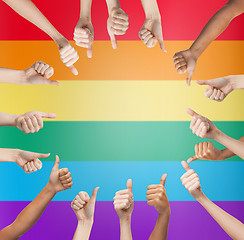 Image showing hands showing thumbs up in circle over rainbow