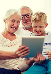 Image showing smiling family with tablet pc at home