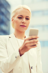 Image showing serious businesswoman with smartphone outdoors