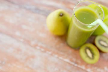 Image showing close up of fresh green juice and fruits on table