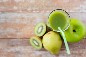 Image showing close up of fresh green juice and fruits on table
