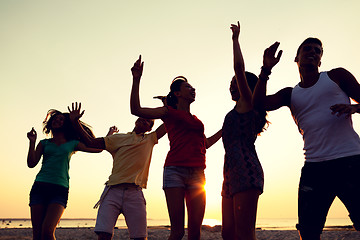 Image showing smiling friends dancing on summer beach