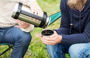 Image showing close up of hikers pouring tea from thermos to cup