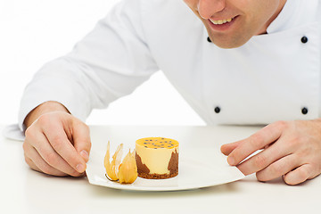 Image showing close up of happy male chef cook with dessert