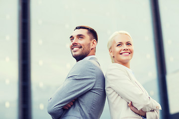 Image showing smiling businessmen standing over office building