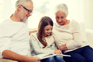 Image showing smiling family with book at home