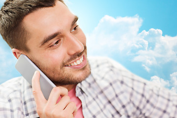 Image showing smiling young man calling on smartphone