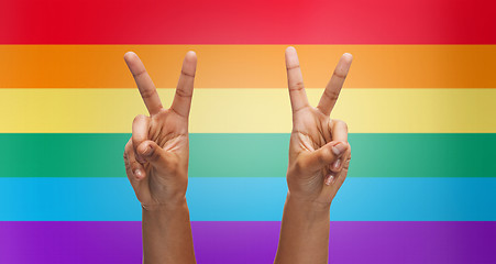 Image showing hands showing peace sign over rainbow stripes