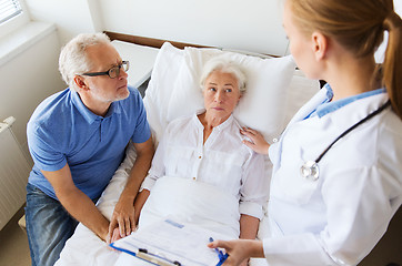 Image showing senior woman and doctor with clipboard at hospital