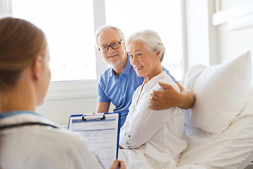 Image showing senior woman and doctor with clipboard at hospital