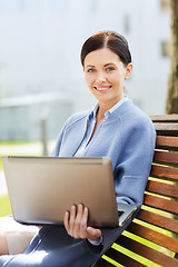 Image showing smiling business woman with laptop in city