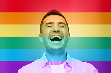 Image showing laughing man over rainbow flag stripes background