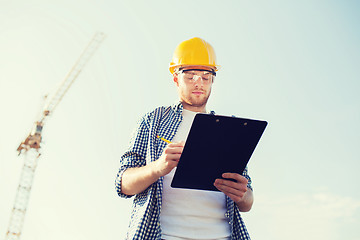 Image showing builder in hardhat with clipboard outdoors