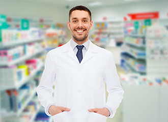 Image showing smiling male pharmacist in white coat at drugstore