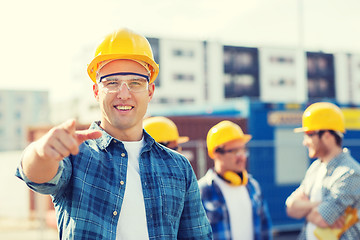 Image showing group of smiling builders in hardhats outdoors