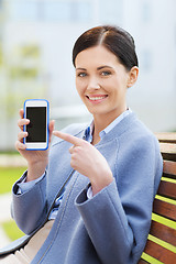 Image showing young smiling businesswoman showing smartphone