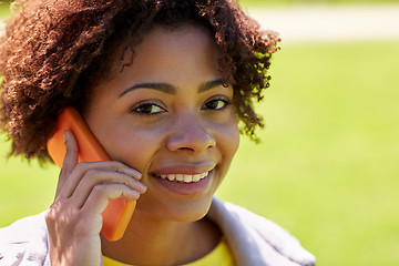 Image showing happy african woman calling on smartphone outdoors