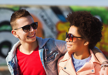Image showing happy teenage friends in shades hugging outdoors