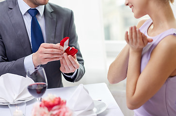 Image showing excited young woman and boyfriend giving her ring