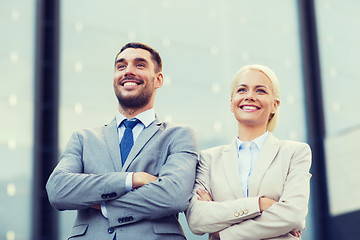 Image showing smiling businessmen standing over office building