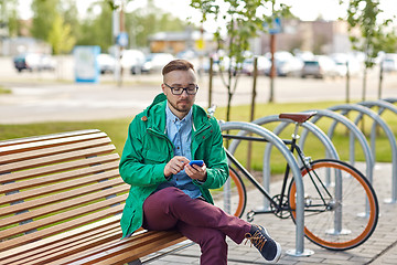 Image showing happy young hipster man with smartphone and bike