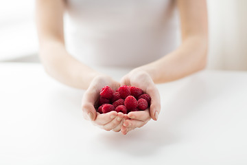 Image showing close up of woman hands holding raspberries