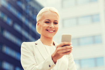 Image showing smiling businesswoman with smartphone outdoors