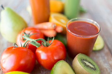 Image showing close up of fresh juice glass and fruits on table