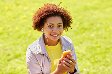 Image showing happy african woman with smartphone and earphones