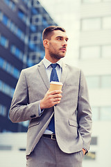 Image showing young serious businessman with paper cup outdoors