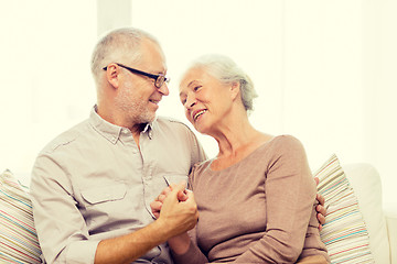 Image showing happy senior couple hugging on sofa at home