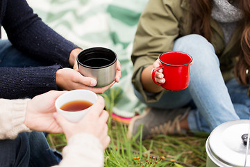 Image showing close up of hikers drinking tea from cups at camp