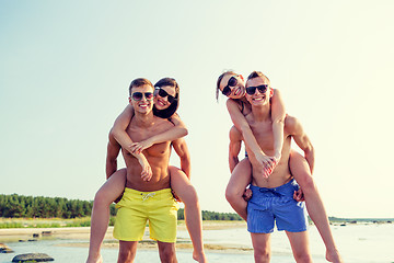 Image showing smiling friends in sunglasses on summer beach