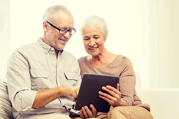 Image showing happy senior couple with tablet pc at home