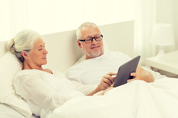 Image showing happy senior couple with tablet pc at home