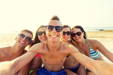 Image showing group of smiling friends making selfie on beach