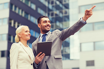 Image showing smiling businessmen with tablet pc outdoors